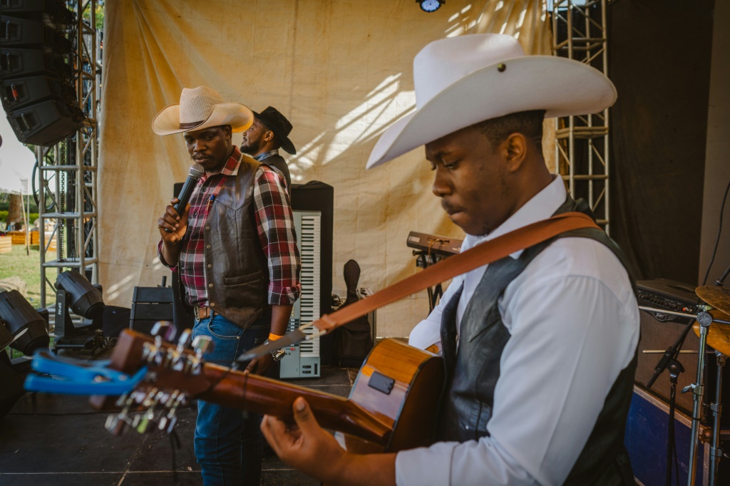 Le chanteur kényan de country Samson Maombi (C) se produit lors de la Journée internationale des cow-boys sur l'hippodrome de Ngong, à Nairobi le 26 juillet 2025.