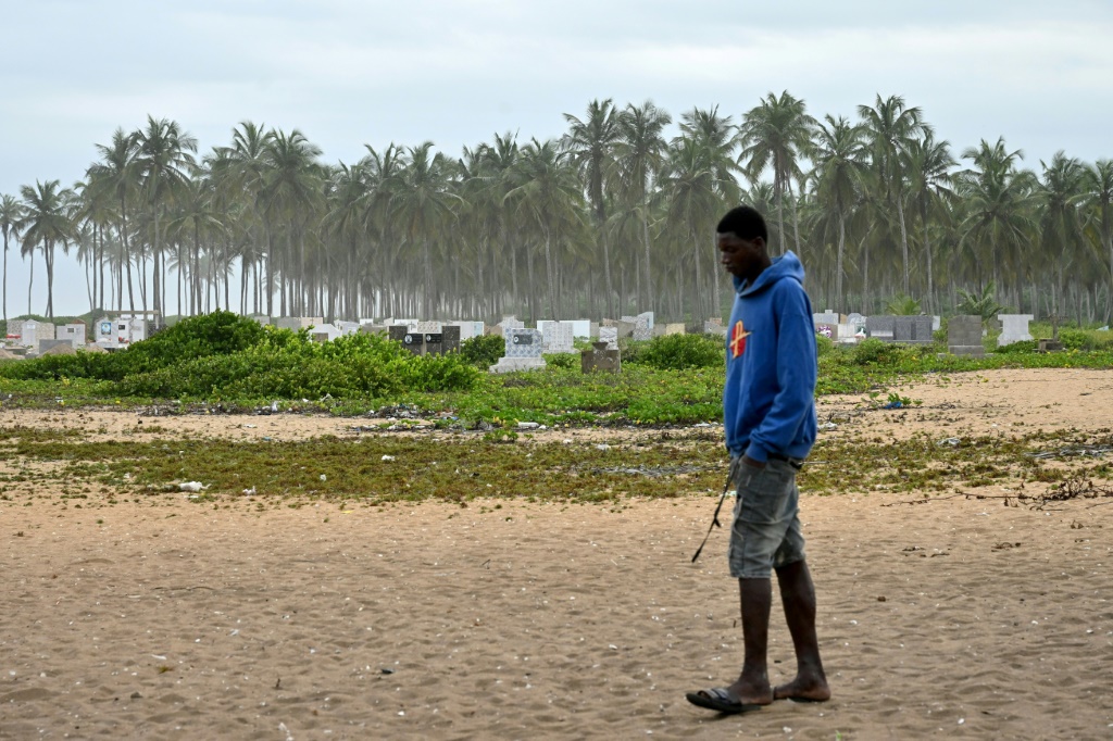 Un homme marche devant le nouveau cimetière de Lahou-Kpanda (Côte d'Ivoire)