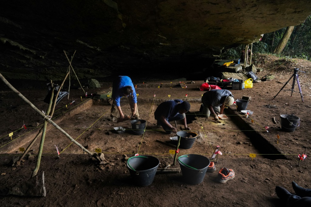 Des étudiants en archéologie participent à des fouilles à l'intérieur de la grotte de Youmbidi à Lastourville (Gabon), le 27 juin 2025.