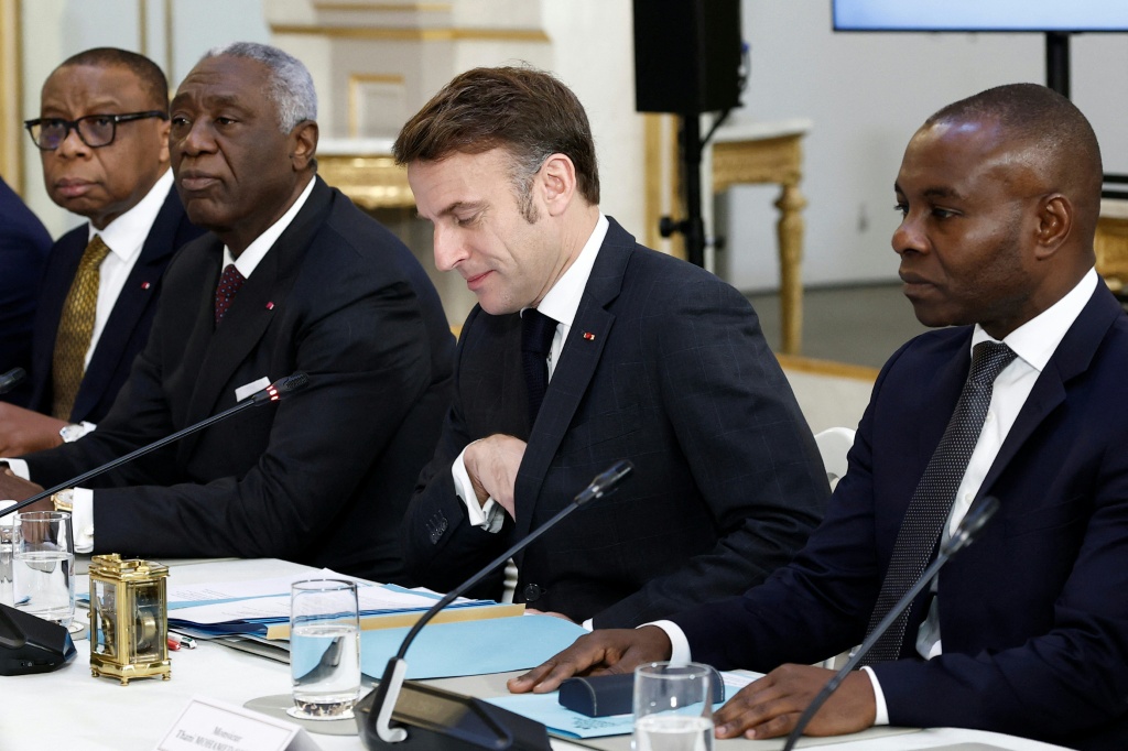 Le Président français Emmanuel Macron (C) avec les membres de la Commission mixte franco-camerounaise, au palais de l'Elysée à Paris le 21 janvier 2025.