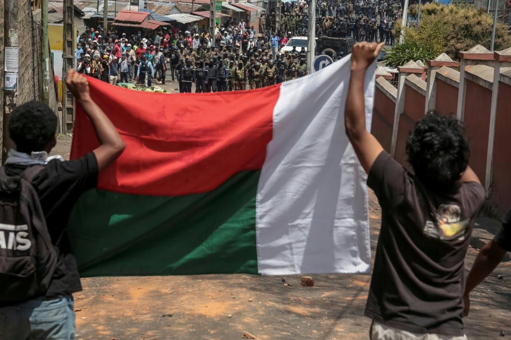 Des manifestants exhibent le drapeau malgache face aux Forces de sécurité lors d'un mouvement de protestation contre les coupures d'eau et d'électricité à Antananarivo, le 25 septembre 2025.
