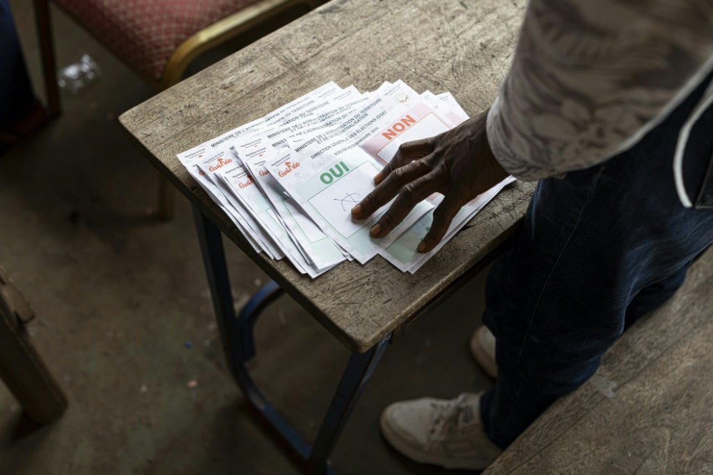 Un employé de la Direction générale des élections de Guinée (DGE) compte les bulletins de vote du bureau de vote de l'Ecole primaire de Taouyah à Conakry le 21 septembre 2025, à l'issue du vote organisé par les militaires au pouvoir sur un projet de nouvelle Constitution.
