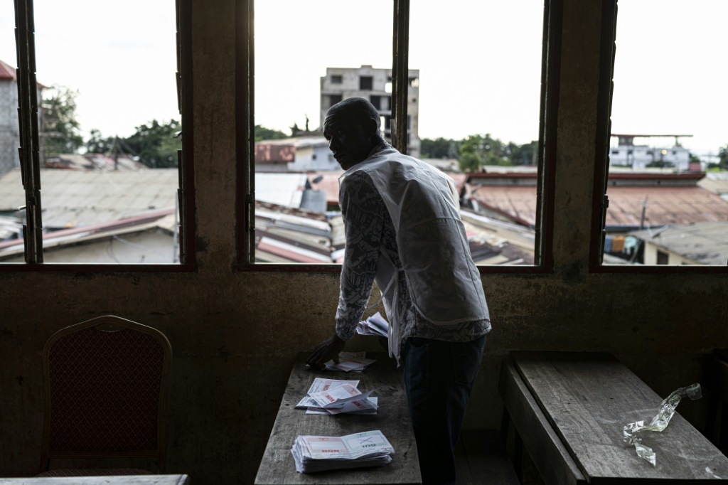 Un employé de la Direction générale des élections de Guinée (DGE) procède au comptage des voix le 21 septembre 2025 d'un bureau de vote situé dans l'école primaire de Taouyah, dans la capitale Conakry. Quatre ans après la prise de pouvoir des militaires, la junte a soumis au vote un projet de nouvelle Constitution.