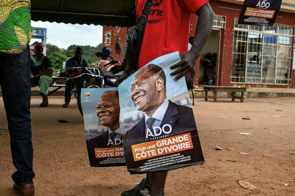 Une affiche de campagne pour le Président ivoirien et candidat à la présidentielle du Rassemblement des houphouétistes pour la démocratie et la paix (RHDP), Alassane Ouattara, sur un marché d'Abobo, une banlieue d'Abidjan, le 18 octobre 2025.