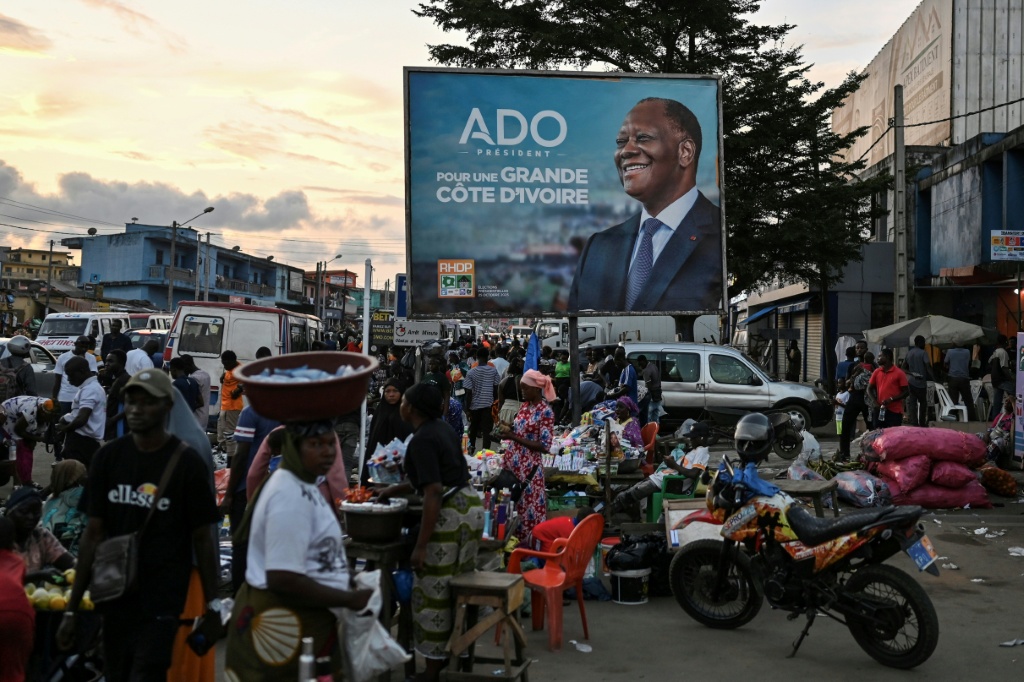 Une affiche de campagne pour le Président ivoirien et candidat à la présidentielle du Rassemblement des houphouétistes pour la démocratie et la paix (RHDP), Alassane Ouattara, sur un marché d'Abobo, une banlieue d'Abidjan, le 18 octobre 2025.