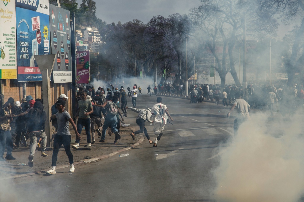 Des manifestants malgaches courent aux abris après des tirs de gaz lacrymogène le 4 octobre 2025 à Antananarivo, capitale de Madagascar.