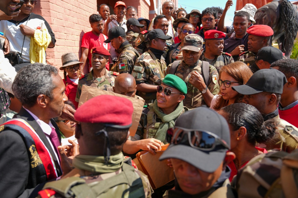 Le colonel Michaël Randrianirina (c) du contingent militaire mutiné du Capsat, parle avec des habitants à son arrivée à Antananarivo, le 16 octobre 2025 à Madagascar.