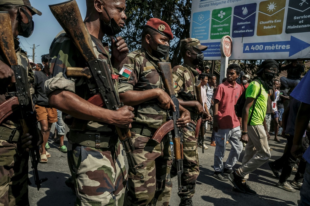 Des membres d'une unité de l'Armée malgache se tiennent dans la rue près de leur camp situé près d'Antananarivo, le 11 octobre 2025.