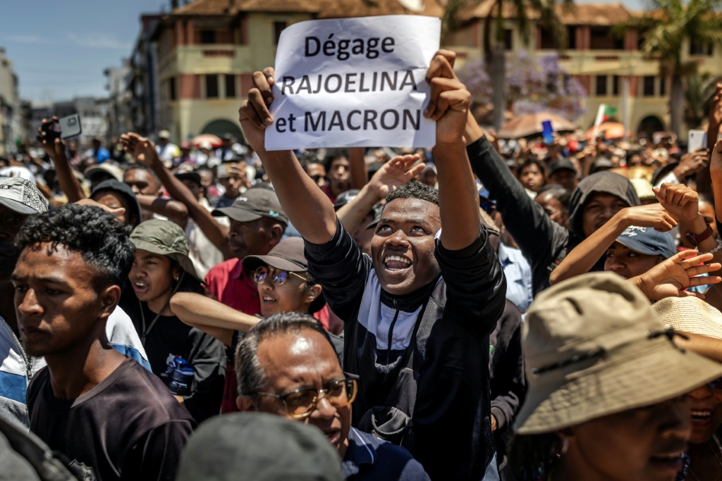Un manifestant brandit une pancarte critique du Président malgache et du Président français lors d'un rassemblement à Antananarivo le 14 octobre 2025.