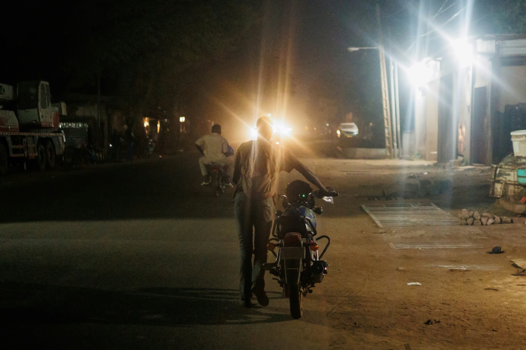 Un homme pousse sa moto qui n'a plus d'essence à Bamako, le 26 octobre 2025.