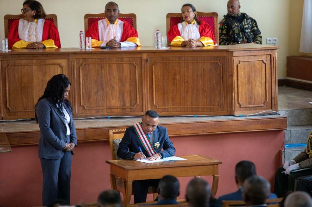 Le colonel Michaël Randrianirina, au centre, signe les documents de sa prestation de serment en tant que Président, pendant sa cérémonie d'investiture, le 17 octobre 2025 à Antananarivo, à Madagascar.
