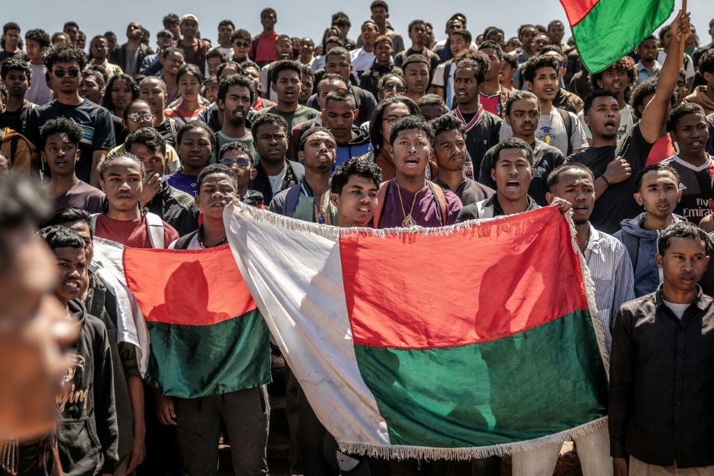 Des étudiants chantent l'hymne national en tenant des drapeaux malgaches avant de se rendre à un rassemblement de la Société civile, à l'Université Ankatso d'Antananarivo, le 13 octobre 2025.