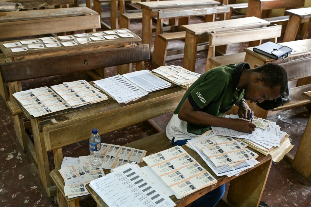 Préparation des cartes d'électeurs dans un bureau de vote à Koumassi, un quartier populaire d'Abidjan, le 20 octobre 2025, avant la prochaine élection présidentielle.