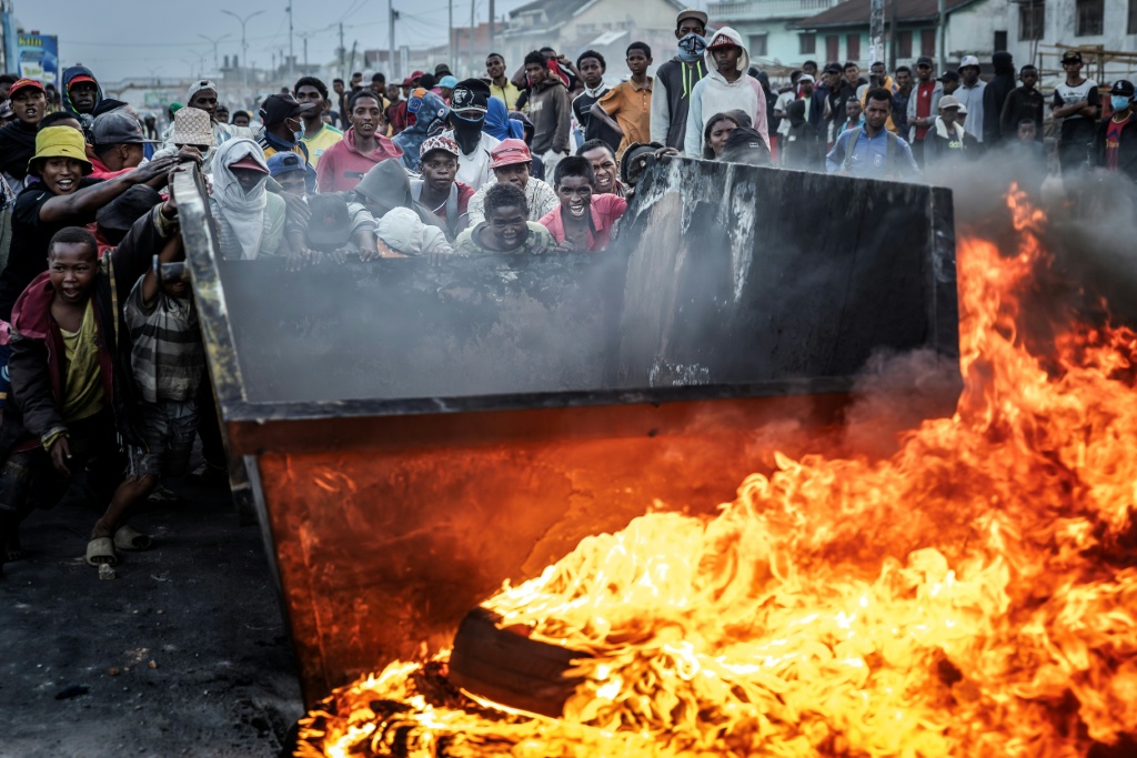 Des manifestants poussent un bac à ordures pour ériger une barricade, le 9 octobre 2025 à Antananarivo (Madagascar).
