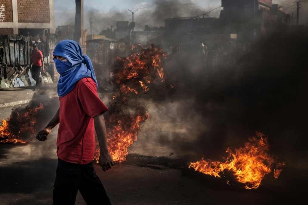 Un manifestant devant des barricades en feu lors d'affrontements avec les Forces de sécurité à Antananarivo, le 7 octobre 2025.