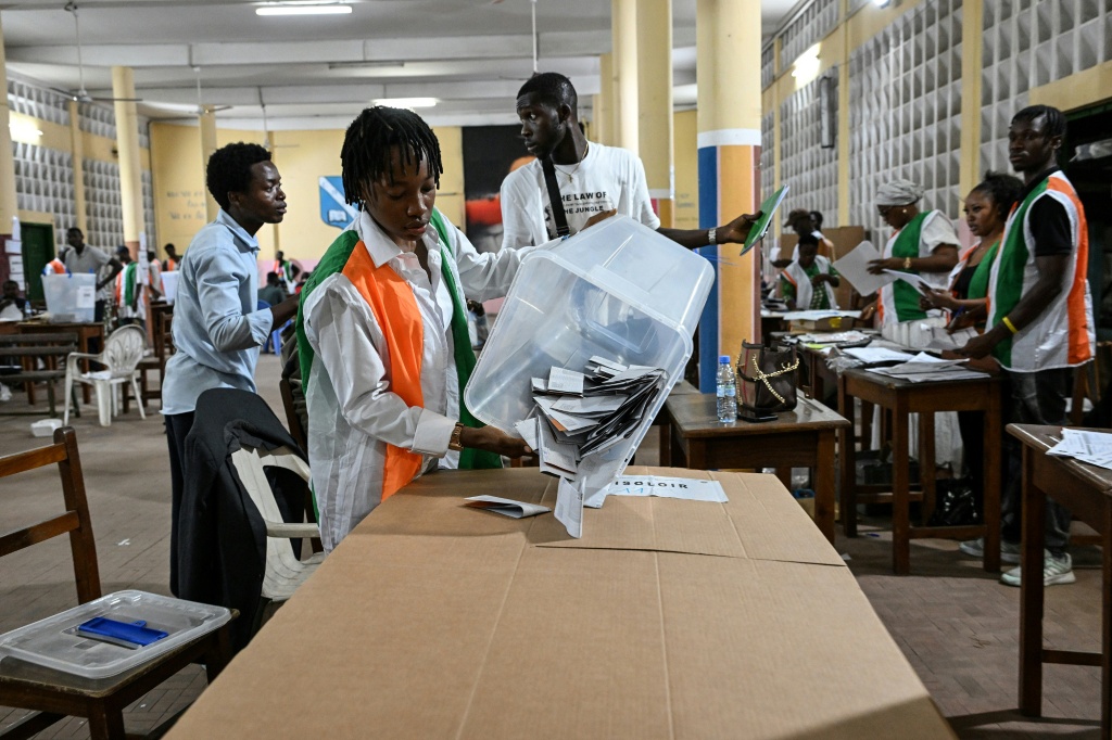 Une représentante de la Commission électorale vide une urne pour le dépouillement des votes de la présidentielle ivoirienne, le 25 octobre 2025 à Abidjan.