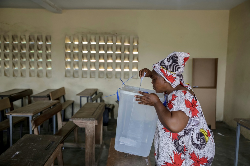 Une femme dépose son bulletin dans l'urne lors de la présidentielle ivoirienne, le 25 octobre 2025 à Abidjan.