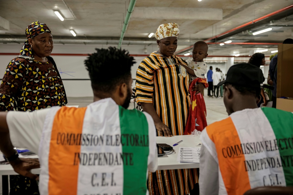 Des représentants de la Commission électorale supervisent les opérations de vote pour la présidentielle ivoirienne, à Abidjan le 25 octobre 2025.