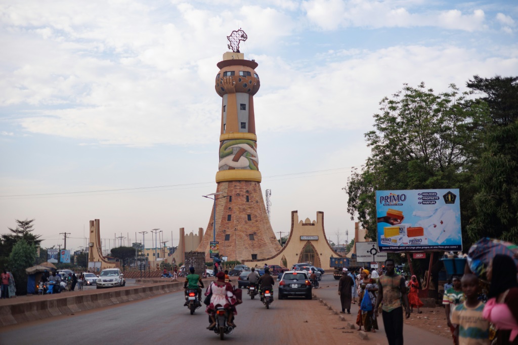 Des automobilistes et des motards roulent en direction de la Tour de l'Afrique, monument symbolisant l'unité des nations africaines, à Bamako, le 8 novembre 2025.