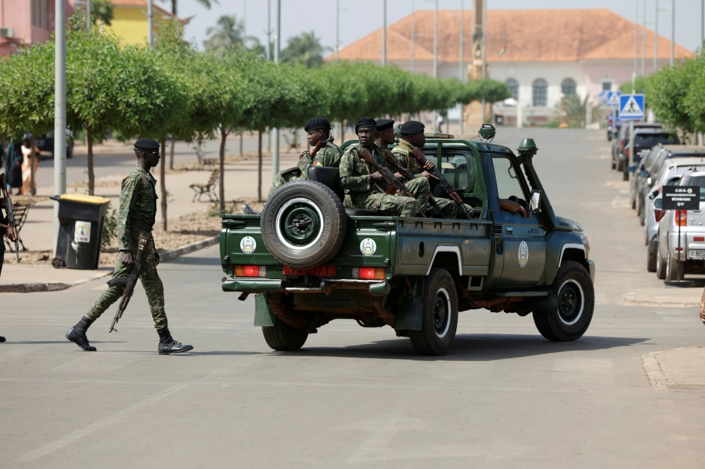 Des soldats armés patrouillent dans une rue près du Palais présidentiel à Bissau, le 26 novembre 2025 en Guinée-Bissau.