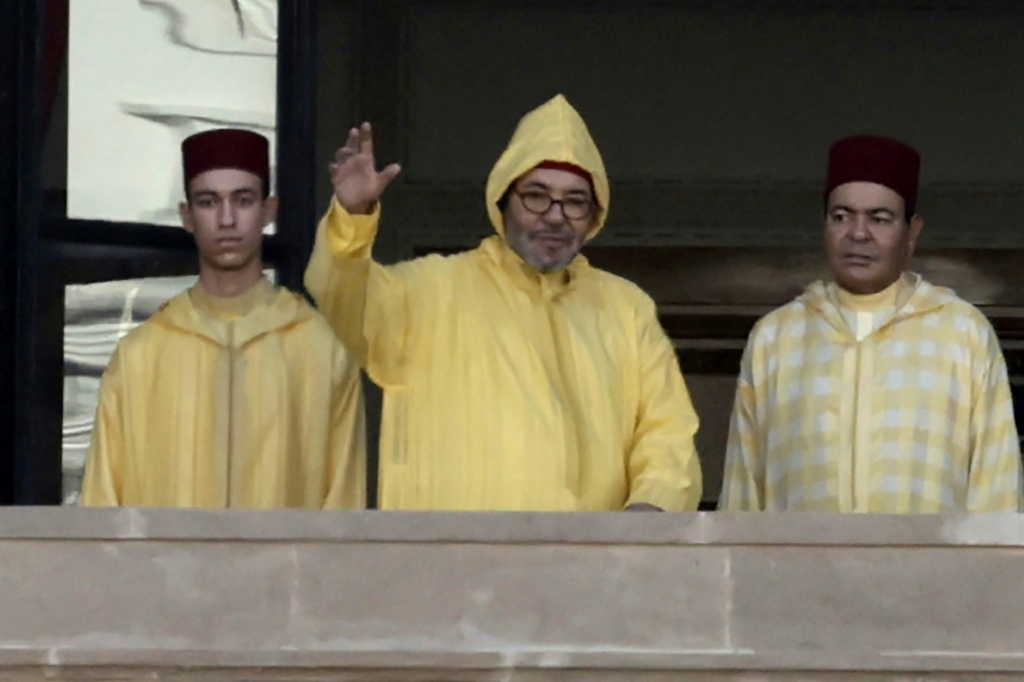 Le Roi du Maroc Mohammed VI (c), accompagné de son fils, le Prince héritier Moulay Hassan (g), apparaît sur le balcon du siège du Parlement à Rabat, le 10 octobre 2025.