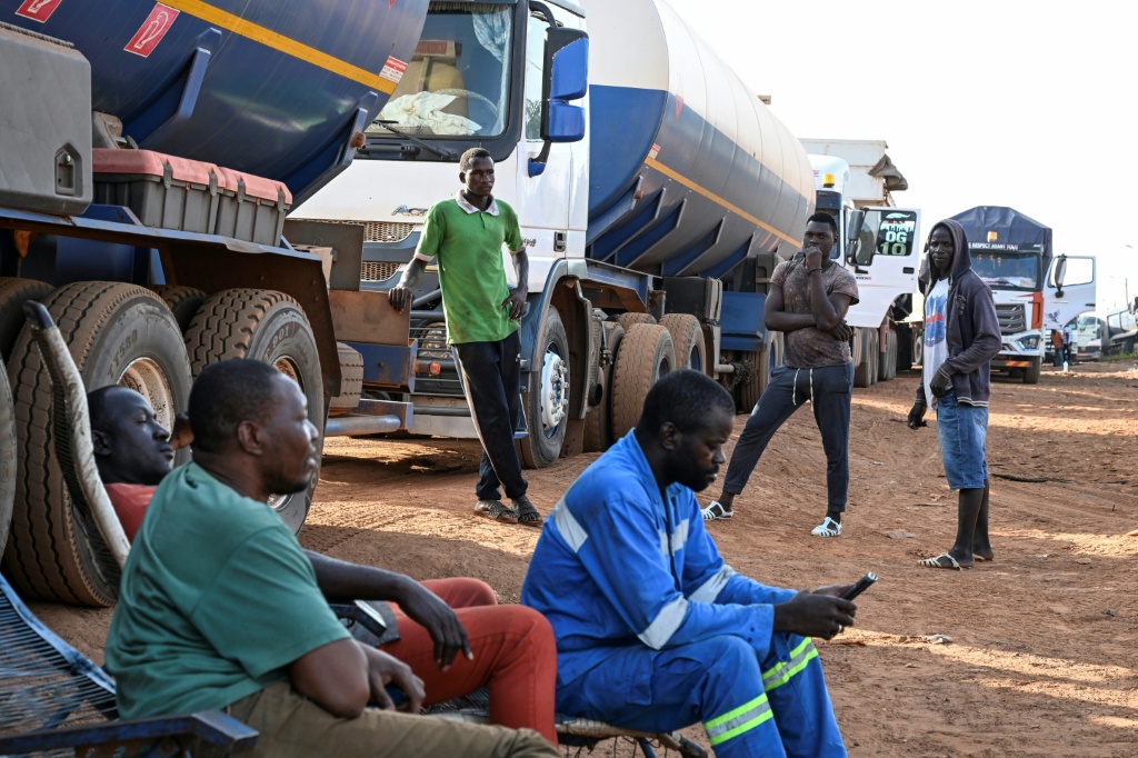 Des chauffeurs de camions-citernes attendent le 31 octobre 2025 à Nigoun à la frontière entre la Côte d'Ivoire et le Mali voisin où ils sont la cible des jihadistes et risquent leur vie.