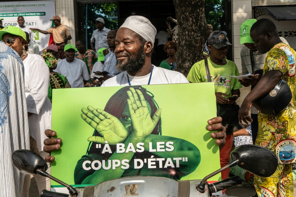 Un partisan du Président du Bénin Patrice Talon montre une pancarte durant un rassemblement de soutien au Chef de l'Etat le 10 décembre 2025 à Cotonou.