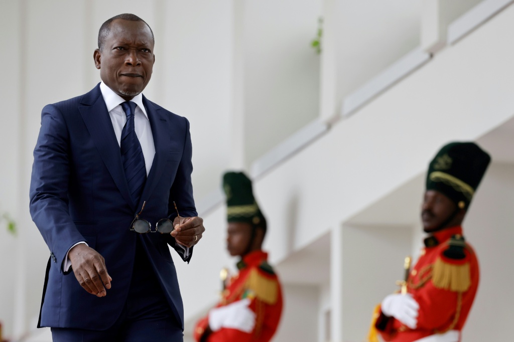 Le Président du Bénin Patrice Talon, encadré par la garde d'honneur, attend l'arrivée de son homologue français Emmanuel Macron au Palais présidentiel de Cotonou le 27 juillet 2022.