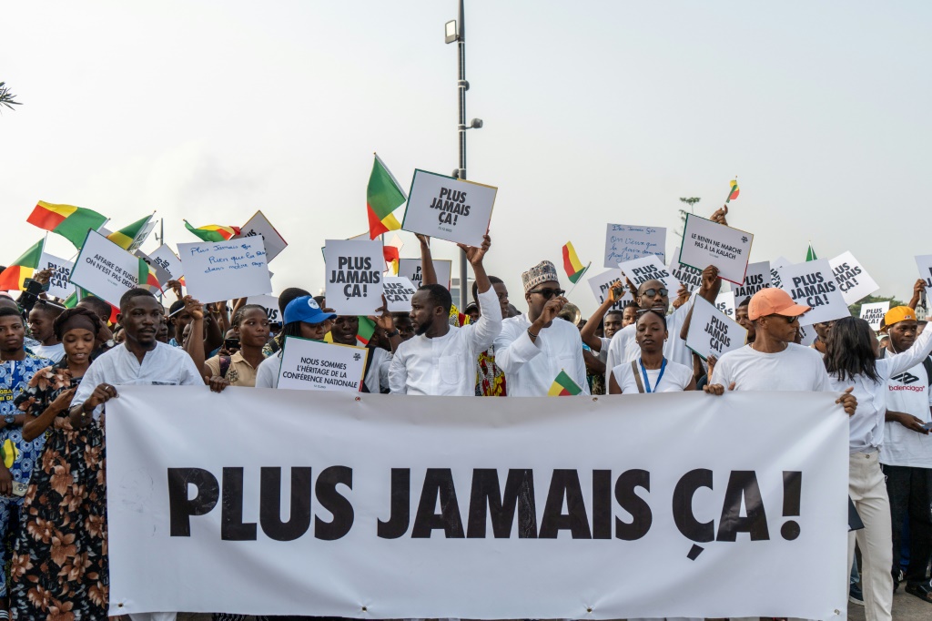 Des partisans du Président du Bénin Patrice Talon tiennent une banderole durant un rassemblement de soutien au Chef de l'Etat le 10 décembre 2025 à Cotonou.