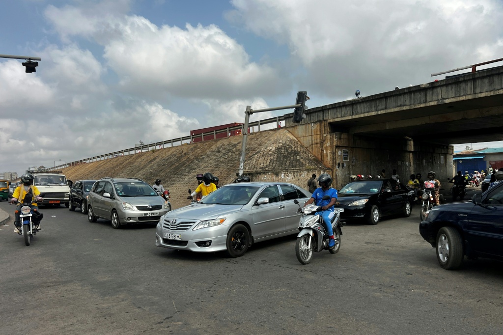 Des automobilistes à Cotonou après que des militaires ont annoncé à la Télévision publique du Bénin avoir "démis de ses fonctions" le Président Patrice Talon, le 7 décembre 2025.