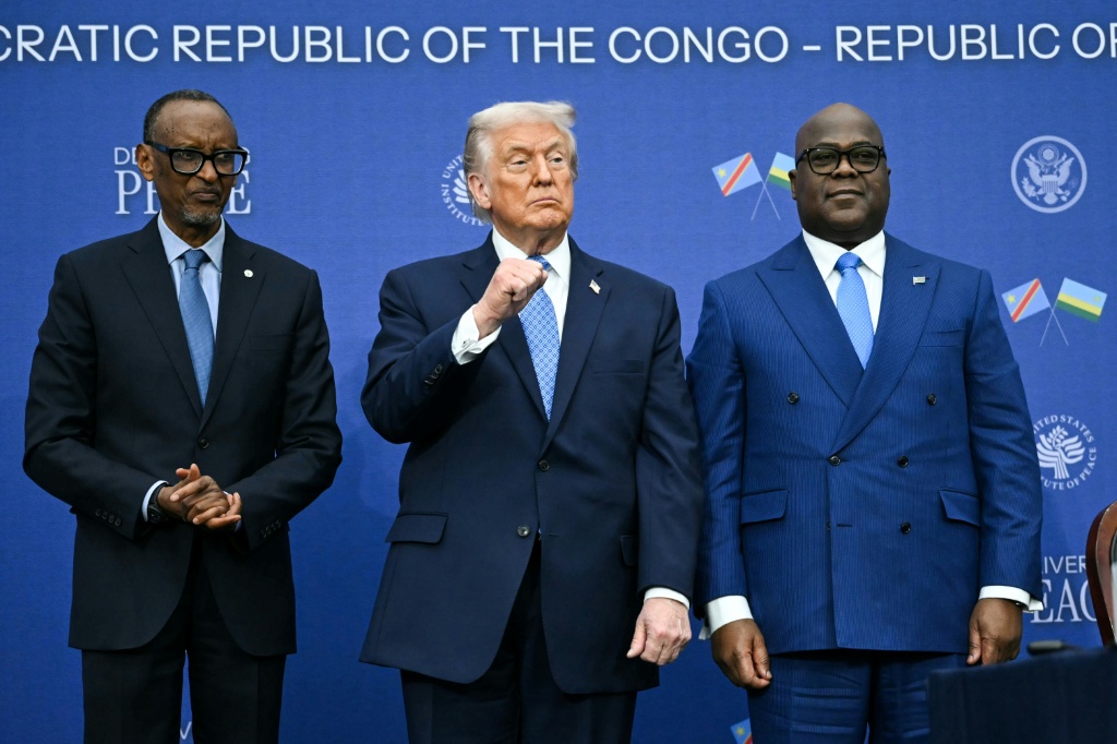 Le Président américain Donald Trump entouré par les Chefs d'Etat rwandais Paul Kagame (G) et congolais Félix Tshisekedi (D) lors de la cérémonie de signature d'un accord de paix, à Washington le 4 décembre 2025.