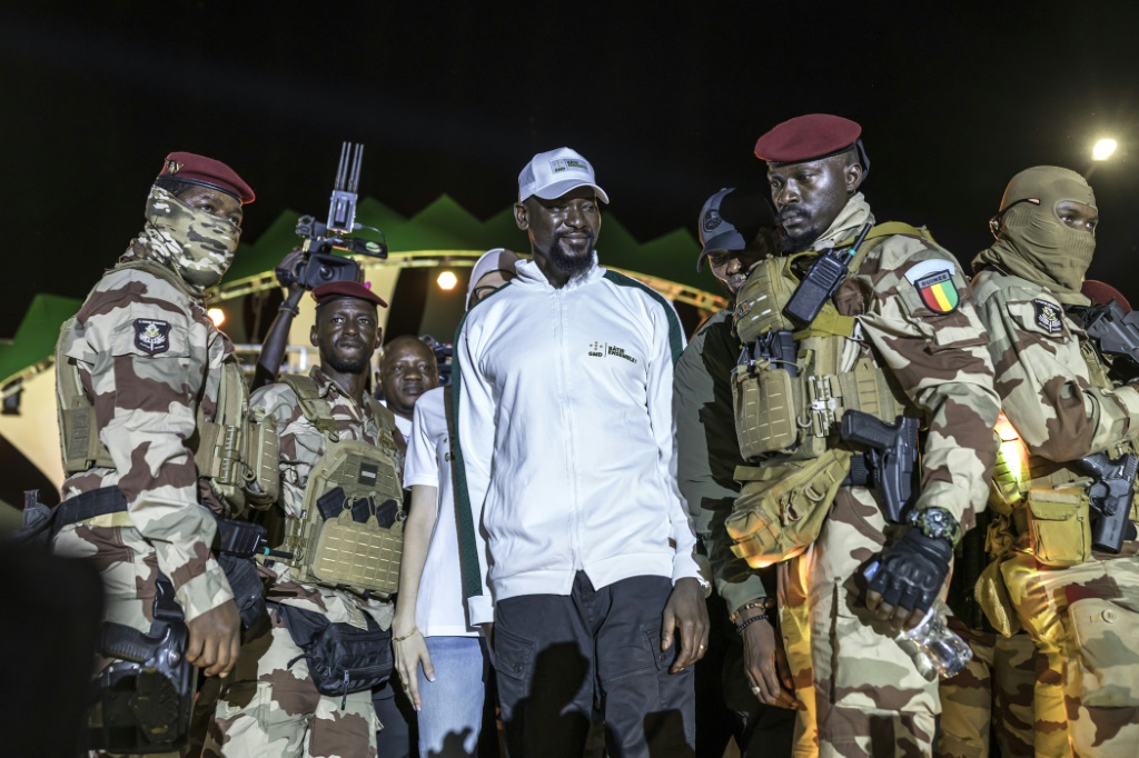 Le Président guinéen et candidat à la Présidence Mamadi Doumbouya (au centre) salue ses partisans lors de son dernier meeting électoral avant l'élection présidentielle, à Conakry, le 25 décembre 2025.