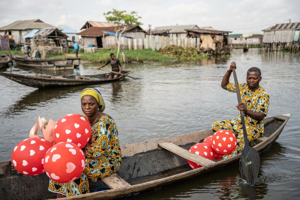 Un couple en pirogue quittent la 'Place des Amoureux' après avoir fêté la Saint-Valentin dans la ville lacustre de Ganvié, le 10 février 2026 au Bénin.