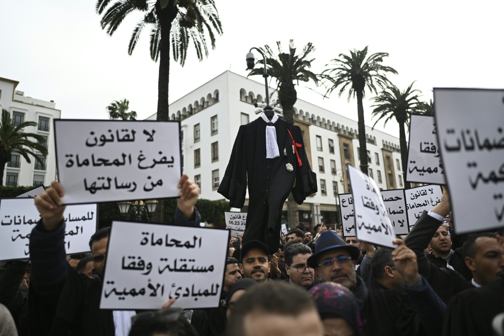Des avocats brandissent des pancartes aux slogans hostiles à une réforme de leur profession, lors d'une manifestation devant le Parlement marocain, à Rabat, le 6 février 2026.