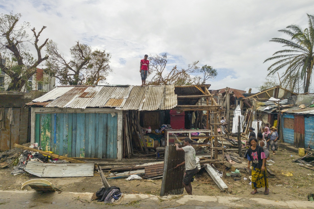 Un habitant sur le toit d'une case endommagée par le passage du cyclone Gezani à Toamasina, sur la côte est de Madagascar, le 12 février 2026.