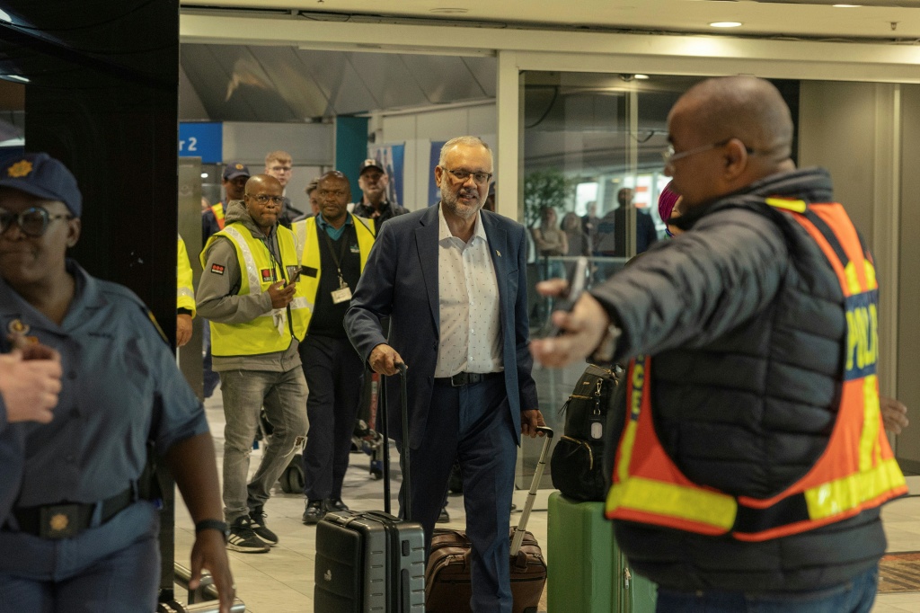 L'ancien ambassadeur d'Afrique du Sud aux États-Unis, Ebrahim Rasool (c), arrive à l'aéroport international du Cap, après son expulsion des Etats-Unis, le 23 mars 2025 en Afrique du Sud.