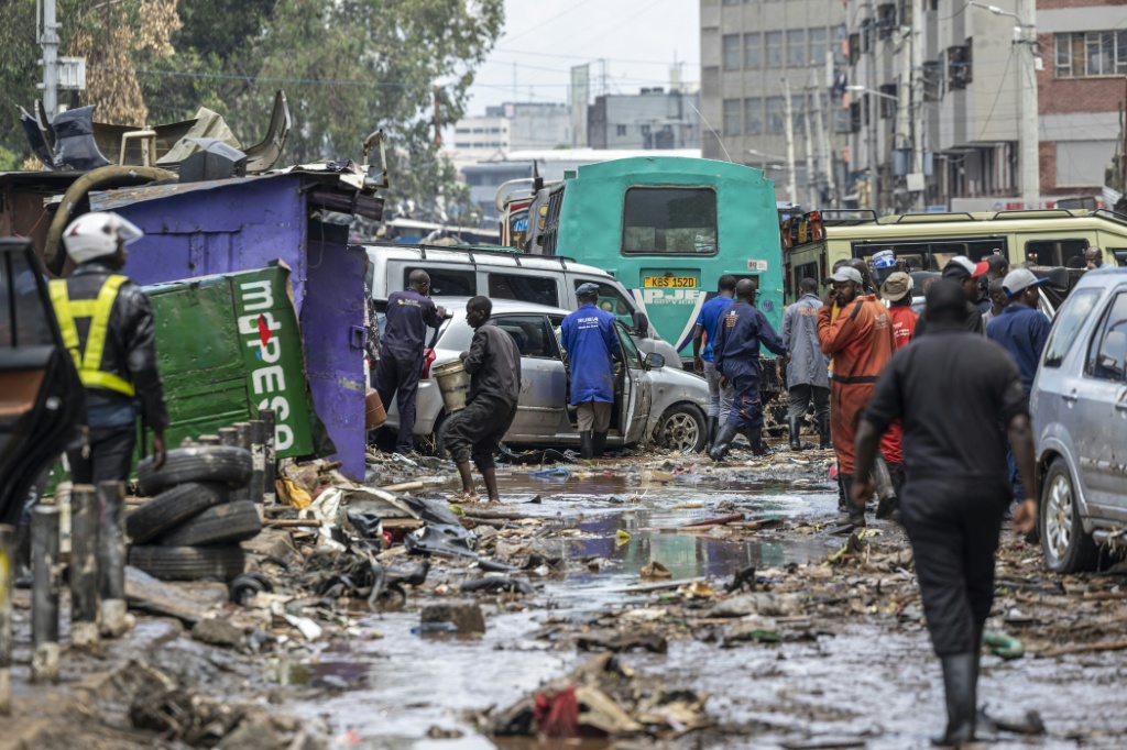 Des habitants récupèrent des biens après une nuit de fortes pluies ayant entraîné d'importantes inondations, le 7 mars 2026 à Nairobi, au Kenya.