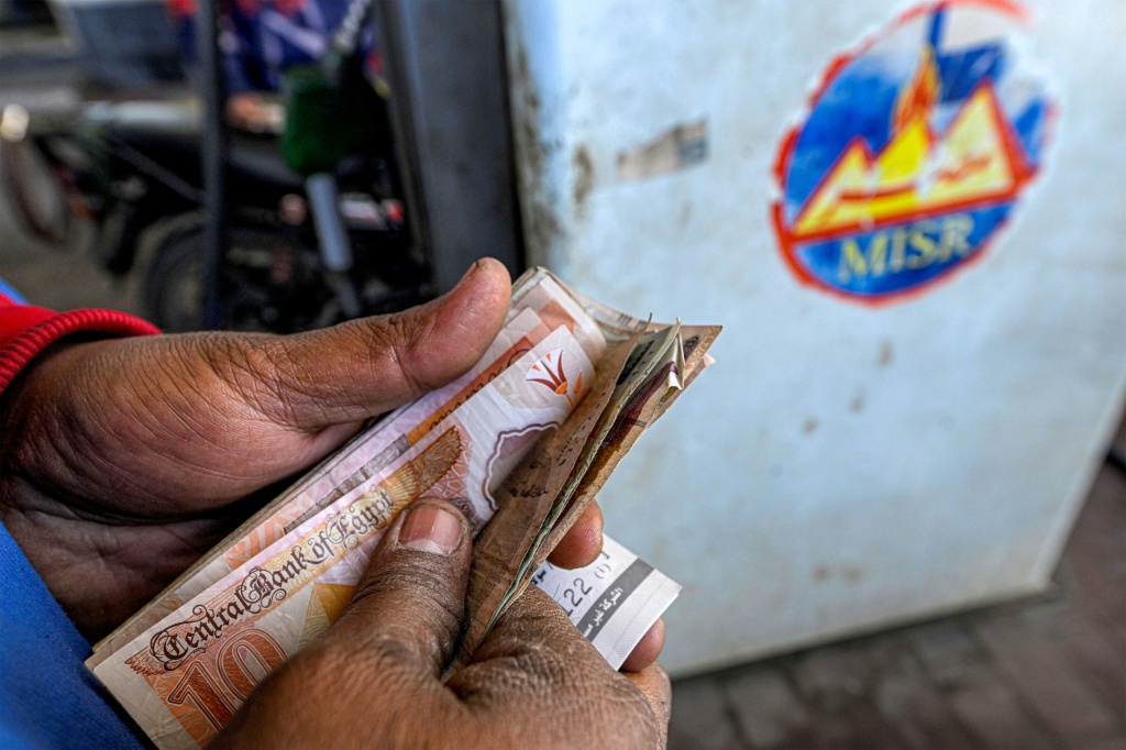 Un employé compte des billets, dans une station-service à Gizeh, en Egypte, le 10 mars 2026.