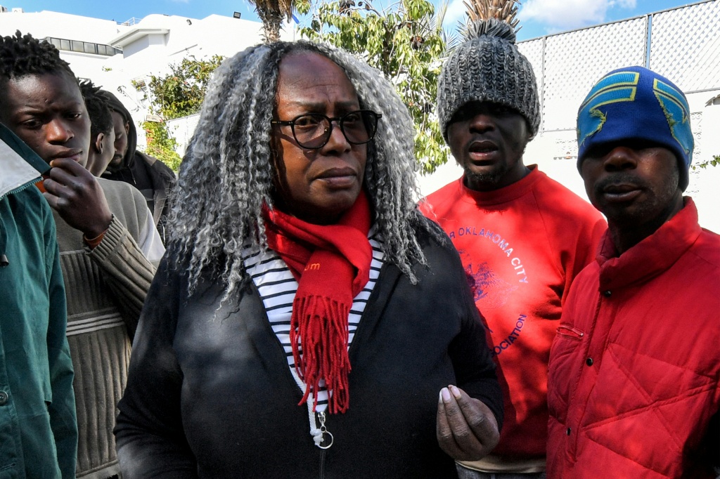 La militante antiraciste tunisienne Saadia Mosbah (c), visite un camp de migrants d'Afrique subsaharienne à l'extérieur du siège de l'Organisation internationale pour les migrations (OIM) à Tunis, le 7 mars 2023.