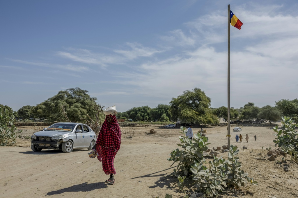 Une femme se dirige vers le poste frontière de Tiné, entre le Tchad et le Soudan, le 8 novembre 2025.