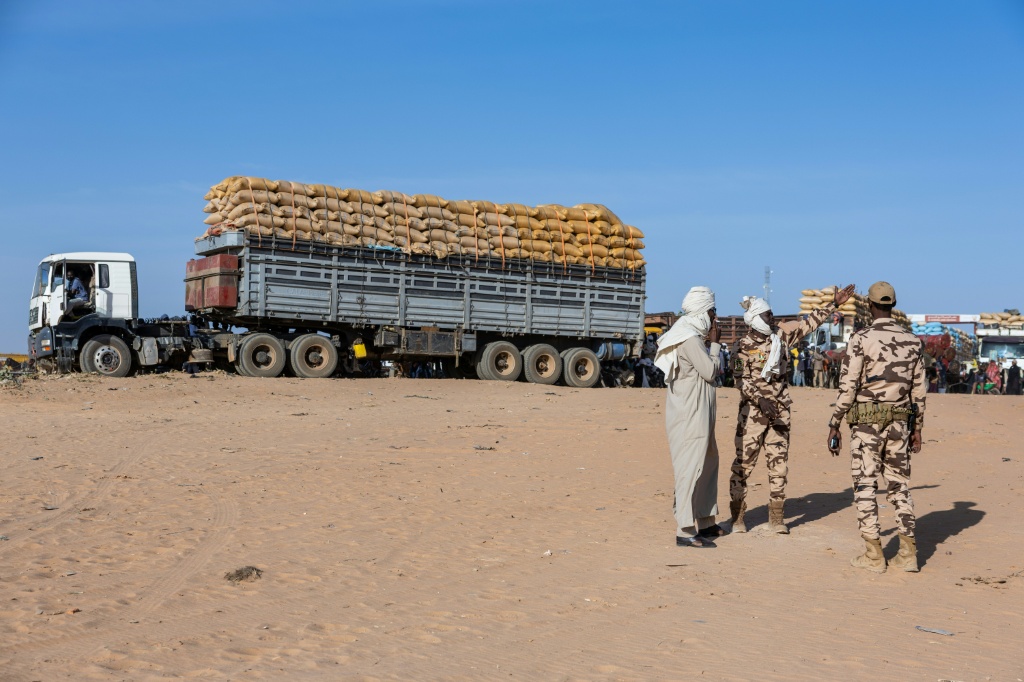 Des soldats tchadiens montent la garde à la frontière avec le Soudan, où des camions sont stationnés, le 14 janvier 2026 à Adré.