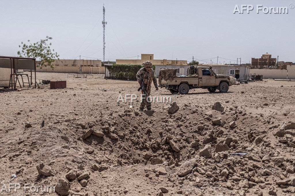 Un combattant de la rébellion indépendantiste du Front de libération de l'Azawad (FLA) inspecte un cratère causé par une frappe aérienne de l'Armée malienne, le 14 mai 2026 à Kidal, dans le nord du Mali.