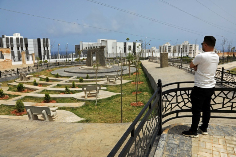 Un homme observe le nouveau projet de logements en construction dans le quartier d'Al-Salam à Derna, le 17 mai 2026, dans le cadre du plan de reconstruction de la ville, près de trois ans après le passage dévastateur d'une tempête qui a fait près de 4.000 victimes.