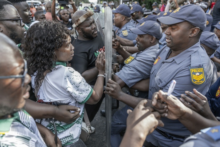 Des membres du mouvement anti-migrants "March and March" face à des policiers, à Durban, le 21 mai 2026 en Afrique du Sud.