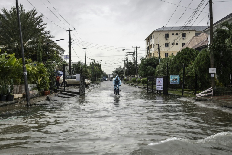 Un homme à vélo dans une rue inondée à Lagos, après des fortes pluies, le 30 juin 2026 au Nigeria