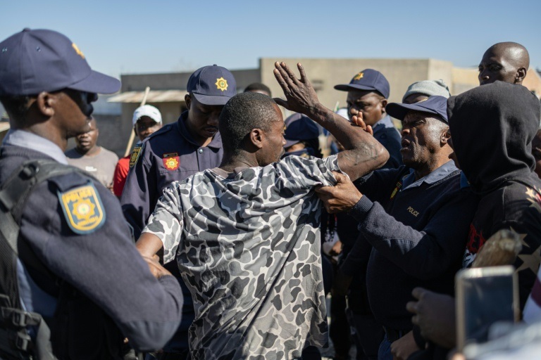 Des policiers arrêtent un manifestant lors d'une manifestation anti-migrants à Alexandra, près de Johannesburg, le 16 juillet 2026 en Afrique du Sud.
