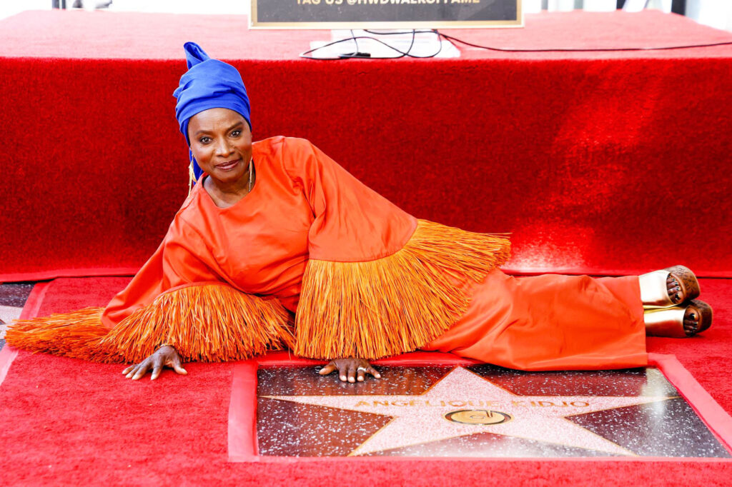La musicienne Angélique Kidjo pose aux côtés de son étoile sur le "Walk of Fame", dans le quartier d'Hollywood à Los Angeles, le 18 août 2026.
