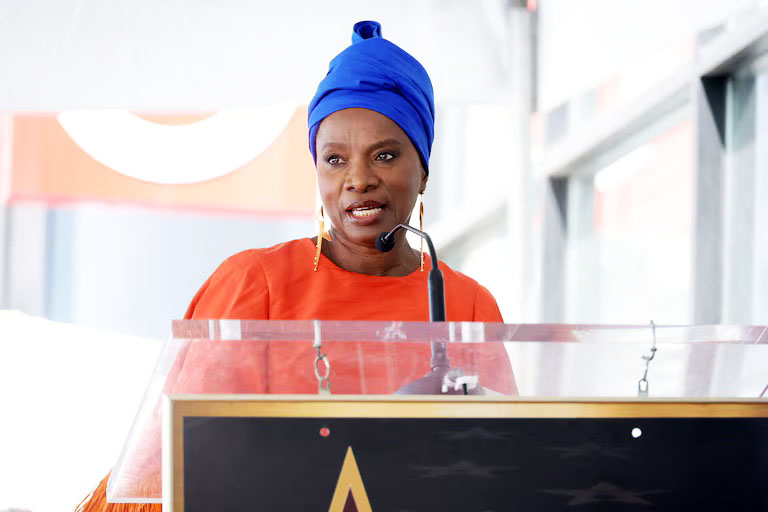 La musicienne Angélique Kidjo pose aux côtés de son étoile sur le "Walk of Fame", dans le quartier d'Hollywood à Los Angeles, le 18 août 2026 (photo, AFP).