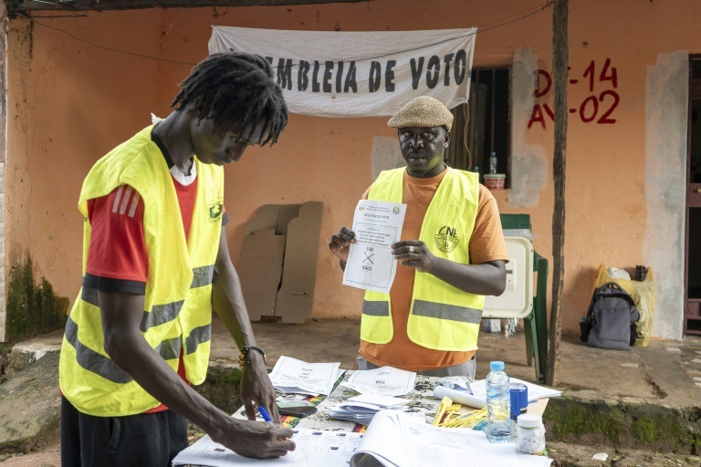 Un responsable de la Commission électorale nationale (CNE) montre un bulletin de vote dans un bureau de vote à Bissau, le 30 août 2026, après le vote de la Guinée-Bissau au référendum constitutionnel